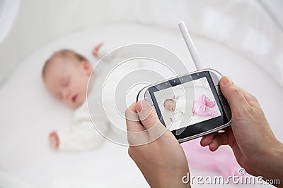 Hand holding video baby monitor for security of the baby Stock Photo