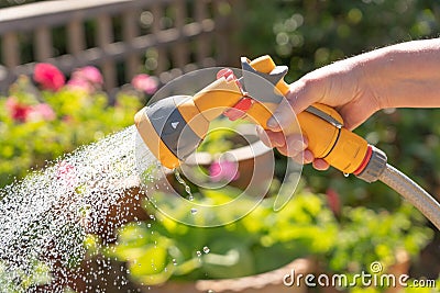 Hand holding a watering hose spray gun. Stock Photo