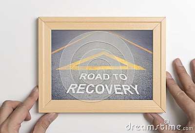 Hand holding wooden frame with road to recovery concept Stock Photo