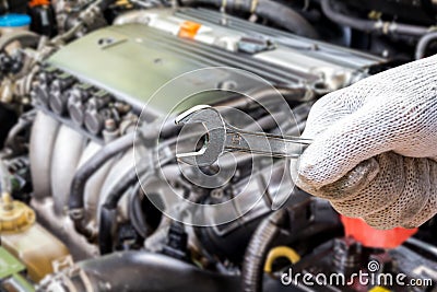 Hand holding wrench on blur car engine Stock Photo