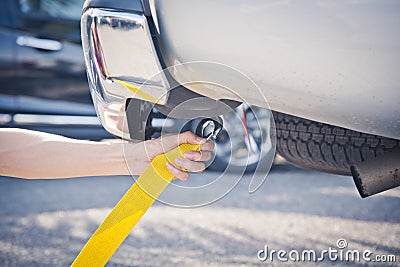 Hand holding yellow car towing strap with car Stock Photo