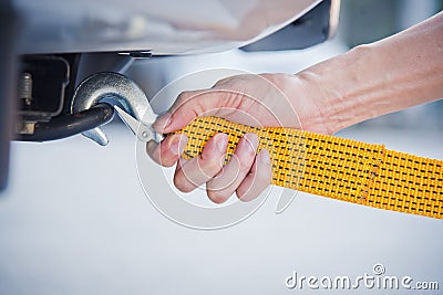 Hand holding yellow car towing strap with car Stock Photo