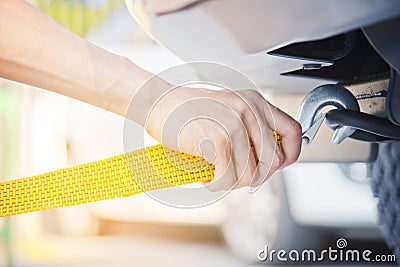 Hand holding yellow car towing strap with car Stock Photo