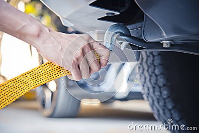 Hand holding yellow car towing strap with car Stock Photo