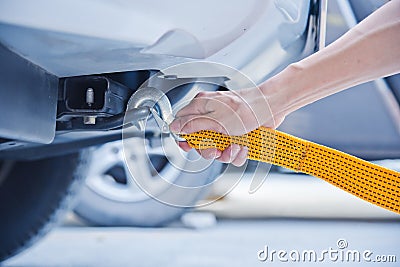 Hand holding yellow car towing strap with car Stock Photo