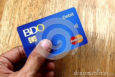 A hand holds a BDO Debit Mastercard. Editorial Stock Photo