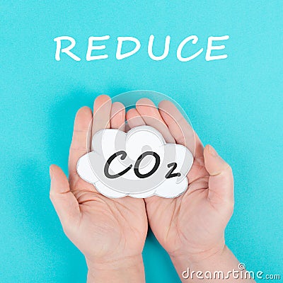 Hand holds cloud with the word CO 2, reduce carbon dioxide emission, environmental issue, air pollution Stock Photo