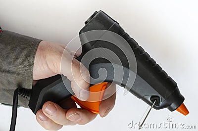 Hand holds an electric glue gun Stock Photo