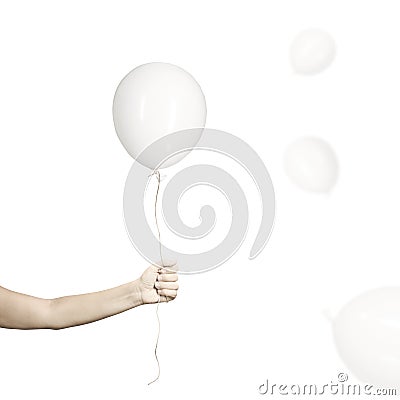 Hand holds his white balloon tight as it tries to escape Stock Photo