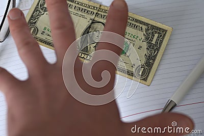 The hand holds the money in the notebook on the desk in the office. A bribe giving. corruption. Dollars for work. work done for mo Stock Photo