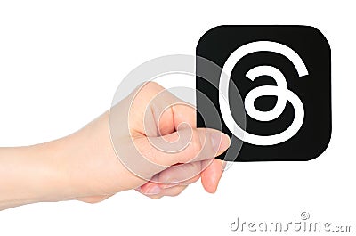 Hand holds paper Threads mobile app icon, on transparent background. Threads is an online social media and social networking Editorial Stock Photo
