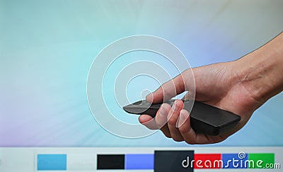 The hand holds the TV remote on background of the smart TV screen. Modern TV. Stock Photo