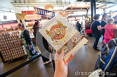 SAN FRANCISCO, CALIFORNIA: A hand holds up a Boudin Bakery cookie package from the famous sourdough bread restaurant Editorial Stock Photo