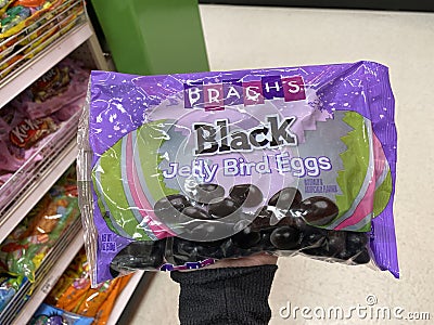 Eau Claire, Wisconsin - March 30, 2020: Hand holds up a package of Black Jelly Beans Brachs brand inside of the Easter Candy sec Editorial Stock Photo