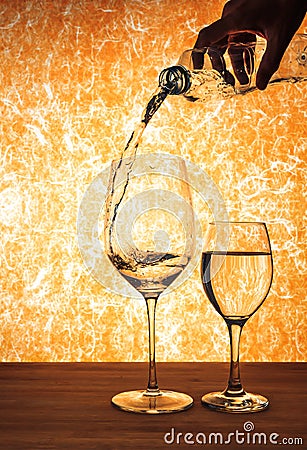 Hand hole bottle and pouring water in to the wine glass. Stock Photo