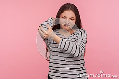 Hand injury. Portrait of woman massaging aching elbow, frowning from acute pain, strain and strain problem Stock Photo