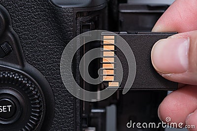 hand insert SD card in camera Stock Photo