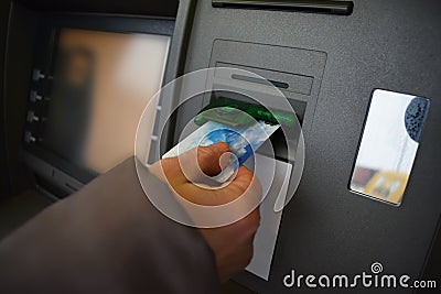 Hand inserting ATM card into bank machine to withdraw money Stock Photo