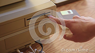 Hand inserting and ejecting Floppy Disk into vintage Commodore Amiga 2000 PC Stock Photo