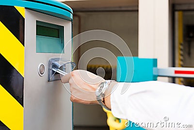 Hand is inserting parking ticket into barrier of g Stock Photo