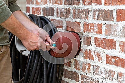 Hand installs faucet cover to protect it from freezing Stock Photo