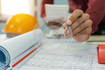 Hand interior designer, engineer or architect drawing on blueprint with safety helmet in meeting room Stock Photo