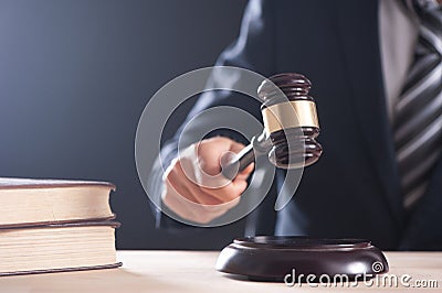 Hand of a judge holding a hammer or gavel Stock Photo