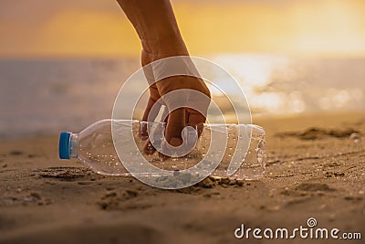 Hand Keep cleanup the Plastic bottle on beach at the sunset sc Stock Photo