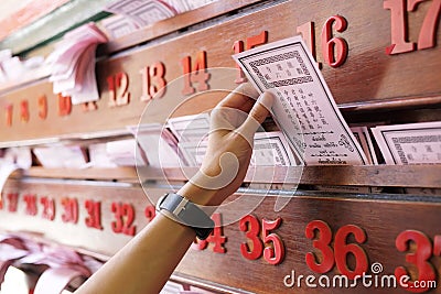 Hand keep fortune paper on shelf Stock Photo