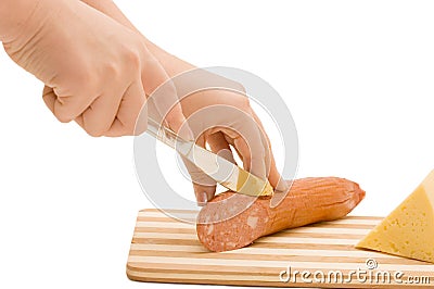 The hand with a knife cuts sausage Stock Photo