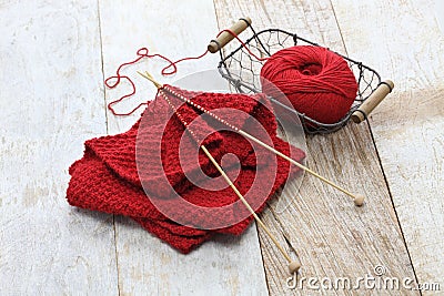 Hand knitted red scarf, yarn ball and knitting needles Stock Photo