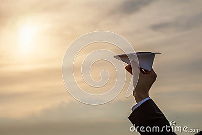 Hand launches an airplane in the direction of the sun Stock Photo