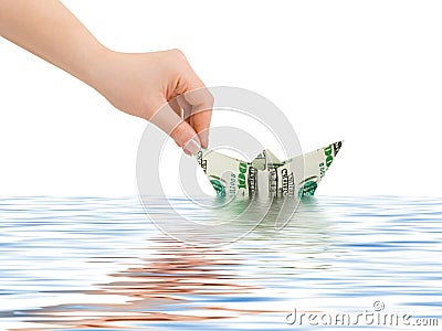 Hand launching money ship Stock Photo