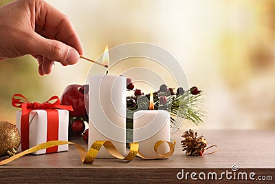 Hand lighting candles on decorated table at Christmas Stock Photo