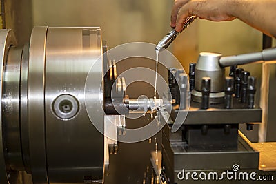 The hand of machine operator setting the coolant tube on late machine. Stock Photo