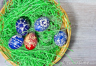Hand made easter egg in green grass and basket on rustick wooden Stock Photo