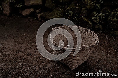 Hand made multipurpose basket made of bamboo on the ground on a mossy stone pile background Stock Photo