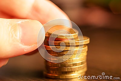 Hand making a pile of golden russian ruble coins . Russian currency Stock Photo