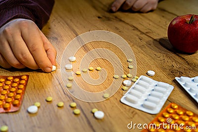hand making sad face out of pills on the table drugs addiction concept Stock Photo