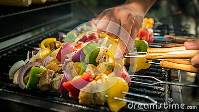 Hand of man with BBQ grill. Cook a delicious skewers on grilled meat in a house Stock Photo