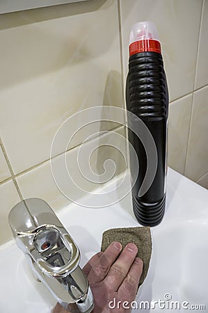 The hand of a man disinfecting the bathroom sink Stock Photo