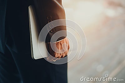 Hand of man in formal suit holdning laptop Stock Photo