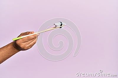 Hand of man holding bass nigiri with chopsticks over isolated pink background Stock Photo