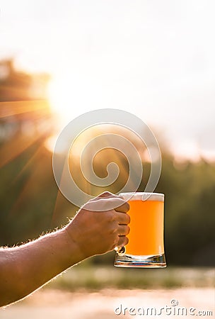 Hand man holding a glass of unfiltered light beer Stock Photo