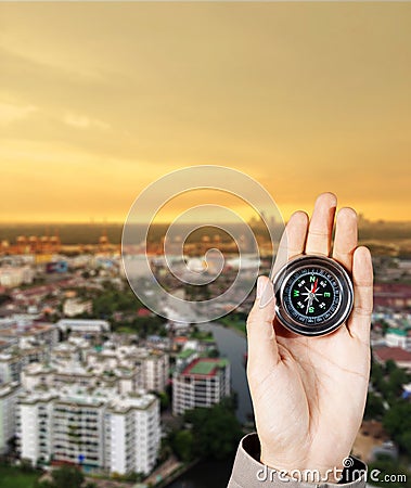 The hand of a man holding a magnetic compass over a city buildings Stock Photo