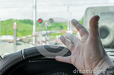 The hand of man inside the car. The car stopped in front of a closed barrier Stock Photo