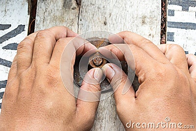 Hand man install rusty nut and bolt on wood Stock Photo