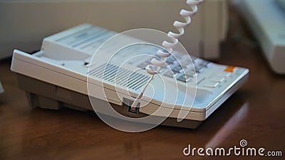 A hand of a man picking up the receiver of a vintage retro telephone and answering the call. Media. Close up of using Stock Photo