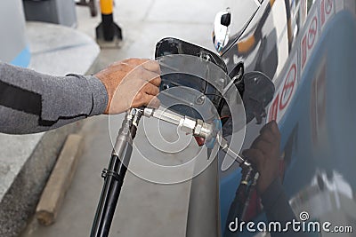 hand of man pumping CNG gas in car at gas station Stock Photo