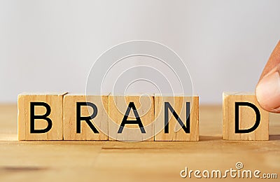 Hand man try to complete the Brand word on wooden cube, Brand concept Stock Photo